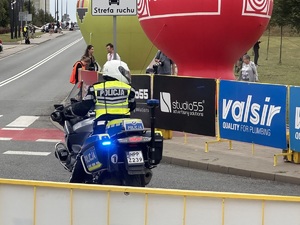 30- zdjęcie kolorowe: policjant ruchu drogowego na motocyklu oczekujący na trasie na swojego kolarza