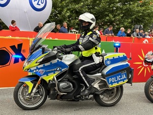 32 – policjant  ruchu drogowego na motocyklu oczekujący na kolarza i wpuszczanie na trasę wyścigu