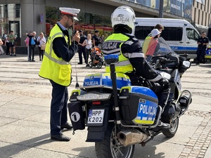 zdjęcie kolorowe: policjant katowickiej drogówki rozmawiający z inspektorem nadzoru ruchu tramwajów
