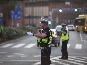 Zdjęcie kolorowe przedstawia policjantów kierujących ruchem.