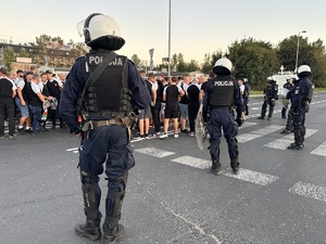zdjęcie kolorowe: policjanci oddziału prewencji przygotowujący się do asysty kroczącej