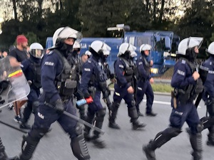 zdjęcie kolorowe: policjanci oddziału prewencji w asyście kroczącej prowadzą kibiców na katowicki stadion
