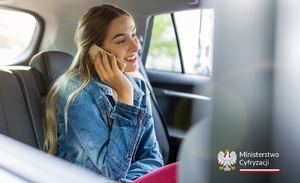 zdjęcie kolorowe: kobieta siedząca w samochodzie, która rozmawia przez telefon i napis o treści Ministerstwo Cyfryzacji