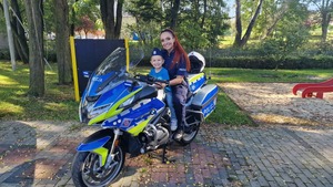 zdjęcie kolorowE: policjantka na motorze z przedszkolakiem podczas pamiątkowego zdjęcia