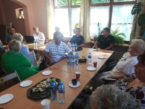 zdjęcie kolorowe: dwóch katowickich dzielnicowych podczas spotkania z seniorami