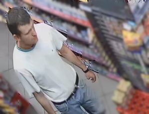 zdjęcie kolorowe: mężczyzna podejrzewany o kradzież w sklepie monopolowym, ubrany w białą koszulkę i niebieskie spodenki jeansowe