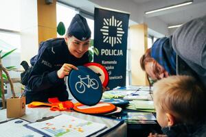 zdjęcie kolorowe: policjantka rozmawiająca z dziećmi o znakach drogowych