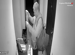 zdjęcie czarno-białe: mężczyzna z plecakiem na ramieniu podejrzany o włamanie do automatu z kawą