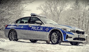 Zdjęcie kolorowe: policyjny radiowóz  w śniegowej scenerii
