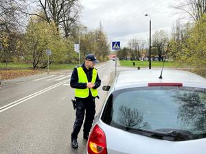 zdjęcie kolorowe: policjant katowickiej komendy podczas kontroli drogowej kierującego pojazdem osobowym