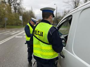 zdjęcie kolorowe: policjanci katowickie drogówki podczas kontroli drogowej kierującego pojazdem osobowym