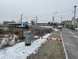 zdjęcie kolorowe: przejeżdżający pociąg po przejeździe kolejowym