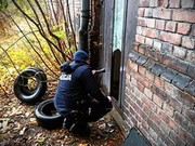 zdjęcie kolorowe: policjant kontrolujący pustostan