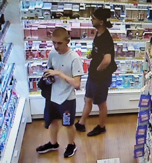 zdjęcie kolorowe: dwóch mężczyzn w sklepie kosmetycznym oglądający perfumy