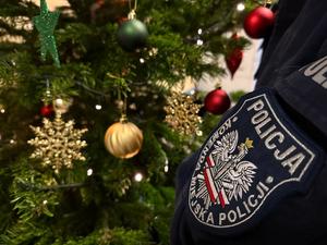 zdjęcie kolorowe: przedstawiające naszywkę Komenda Miejska Policji w Katowicach na tle choinki z ozdobami świątecznymi