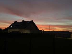 zdjęcie kolorowe: dom na tle zachodzącego słońca
