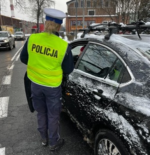 zdjęcie kolorowe: policjantka ruchu drogowego podczas kontroli trzeźwości kierujących