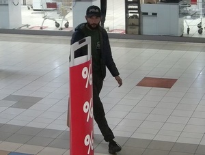zdjęcie kolorowe: mężczyzna podejrzewany o kradzież w sklepie, ubrany w ciemne spodnie, ciemną bluzę i czapkę z daszkiem