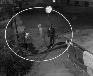 zdjęcie czarno białe: 4 młodych mężczyzn stojących koło budynku