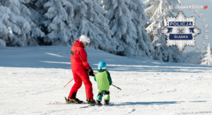 zdjęcie kolorowe: dorosły narciarz z dzieckiem na stoku