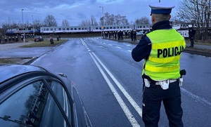zdjęcie kolorowe: komisarz Dawid Szklacheta podczas słuzby w trakcie zabezpieczenia przemarszu kibiców