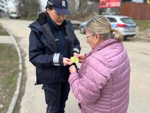 zdjęcie kolorowe: katowiccy policjanci podczas akcji „Patrz i słuchaj – Bezpieczeństwo Pieszych" rozdający przechodniom opaski odblaskowe