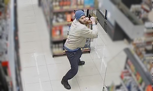 zdjęcie kolorowe: mężczyzna w sklepie który zabrał alkohol z półki