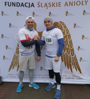zdjęcie kolorowe: dwóch katowickich policjantów podczas pamiątkowego zdjęcia zrobionego po biegu aniołów