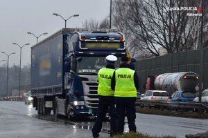 zdjęcie kolorowe: policjanci katowickiej drogówki stojący przy jezdni podczas działań „TRUCK &amp; BUS”