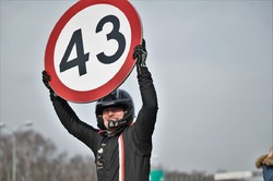 zdjęcie kolorowe: kierujący trzymający znak