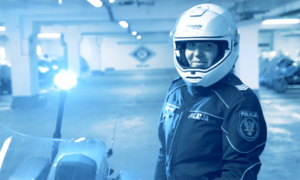 zdjęcie kolorowe przedstawiające policjantkę w ubraniu motocyklowym oraz z kaskiem na głowie
