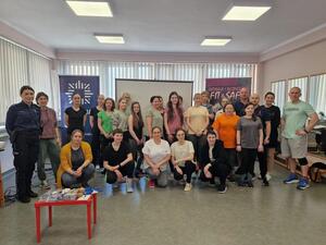 zdjęcie kolorowe: grupa kobiet uczestnicząca w warsztatach z samoobrony podczas pamiątkowego zdjęcia a katowicka policjantką