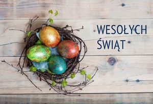 zdjęcie kolorowe: kartka świąteczna przedstawiająca pisanki w koszyku i napisy o treści Wesołych Świąt