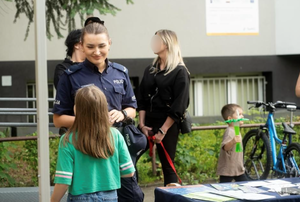 zdjęcie kolorowe przedstawiające policjantkę rozmawiającą z dziewczynką