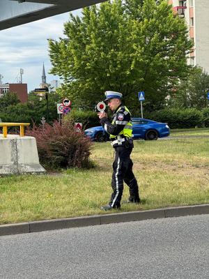 zdjęcie kolorowe przedstawiające policjanta dokonującego pomiaru prędkości