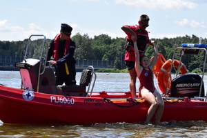zdjęcie kolorowe: policjant z ratownikiem WOPR podczas wspólnych ćwiczeń z ratownictwa wodnego