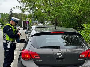 zdjęcie kolorowe: policjant katowickiej drogówki podczas kontroli prędkości w ramach działań "Prędkość"