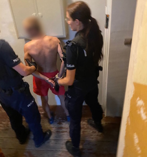 zdjęcie kolorowe: policjanci z zatrzymanym mężczyzną