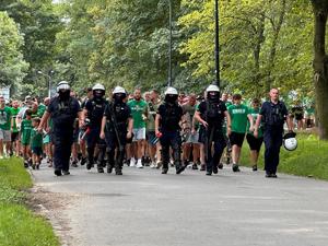 zdjęcie kolorowe: policjanci oddziału prewencji zabezpieczający przemarsz kibiców na mecz