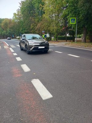 Zdjęcie kolorowe, funkcjonariusz dokonujący kontroli trzeźwości