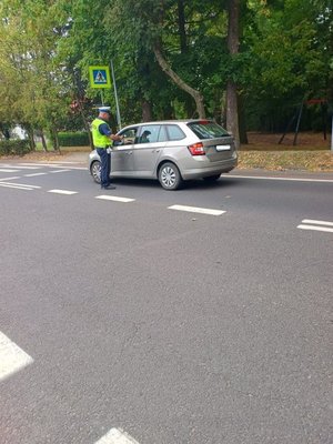 Zdjęcie kolorowe, funkcjonariusz dokonujący kontroli trzeźwości