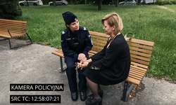 zdjęcie kolorowe: policjantka siedząca na ławce, która rozmawia z kobietą