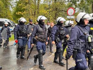 zdjęcie kolorowe: policjanci oddziału prewencji zabezpieczający przemarsz kibiców na mecz piłki nożnej rozegrany pomiędzy drużynami GKS-u Katowice i Pogoni Szczecin