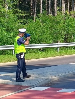 Zdjęcie kolorowe przedstawiające Funkcjonariusza badającego prędkość