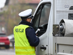 zdjęcie kolorowe: policjant ruchu drogowego wykonujący badanie trzeźwości kierującego samochodem