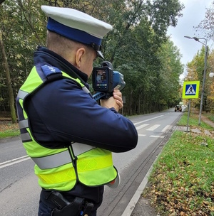 Na zdjęciu policjant z urządzeniem do pomiaru prędkości