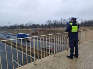 Na zdjęciu widoczny umundurowany policjant mierzący prędkość za pomocą miernika prędkości