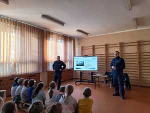 Na zdjęciu dzielnicowi z dziećmi podczas spotkania