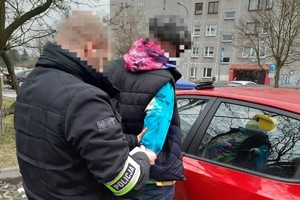 Na zdjęciu widoczny policjant z zatrzymanym mężczyzną.