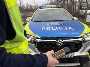 na zdjęciu funkcjonariusz Policji i radiowóz